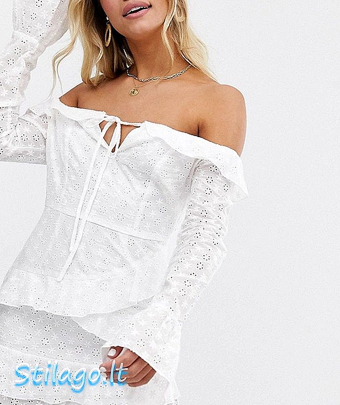 In The Style x Dani Dyer menanggalkan gaun mini ruffle renda bahu dengan hem asimetris berwarna putih